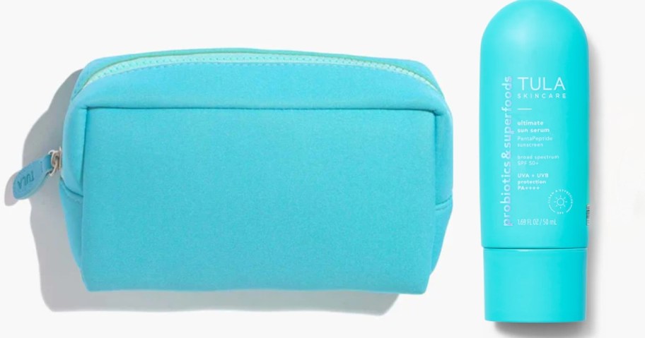 blue zipper cosmetic bag next to a blue bottle of Tula sunscreen