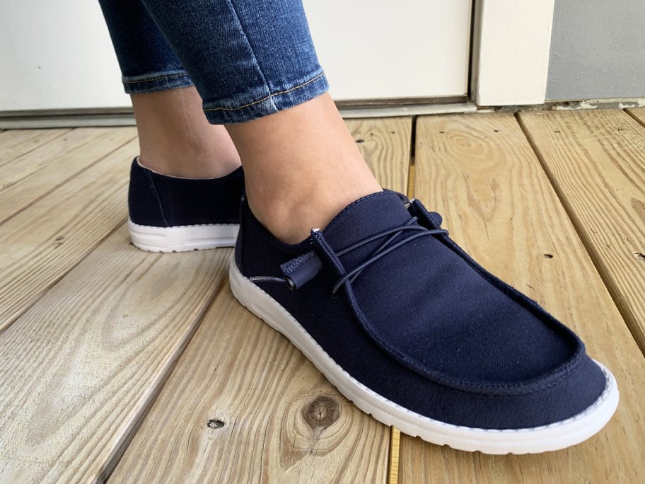 person wearing navy blue canvas shoes