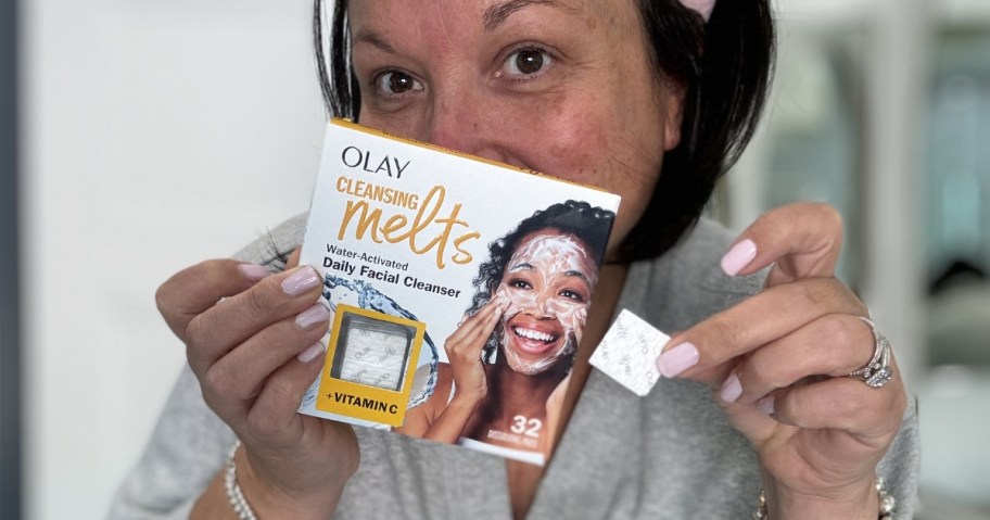 person holding a box of Olay Cleansing Melts with a single one in the other hand