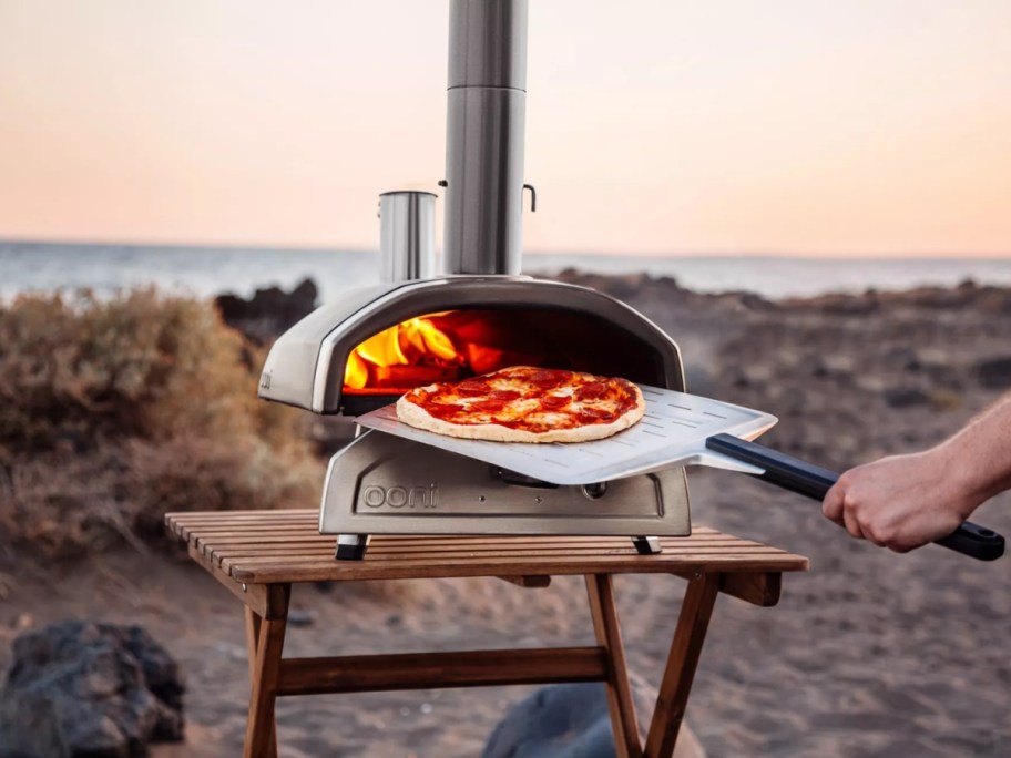 large stainless steel outdoor pizza oven on a table