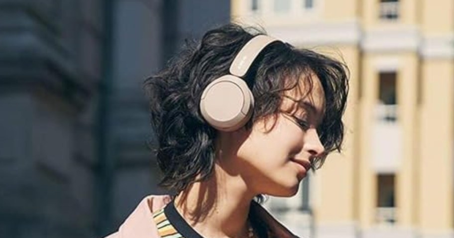 woman outside wearing a Sony Wireless On-Ear Bluetooth Headset smiling 