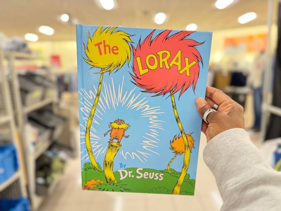hand holding Kohl's Cares The Lorax Hardcover Book inside a Kohl's store