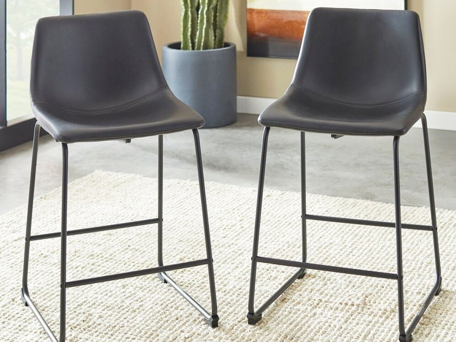two dark grey faux leather barstools