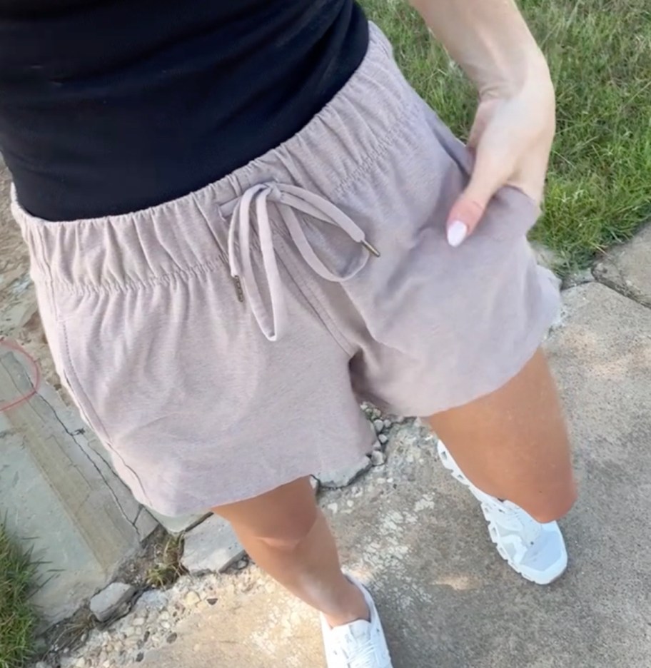 close up of woman wearing beige colored shorts