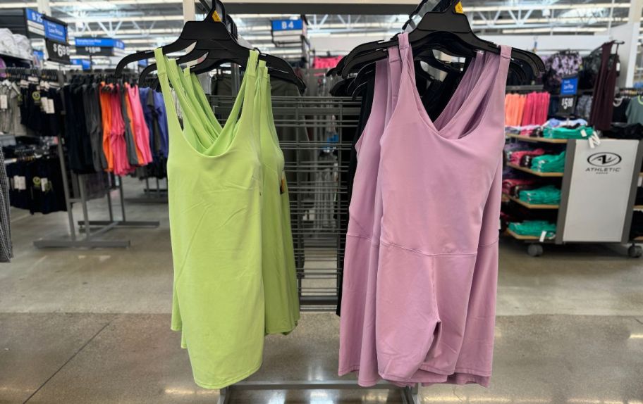 a performance tank dress and romper hanging on a clothing rack in a walmart store.