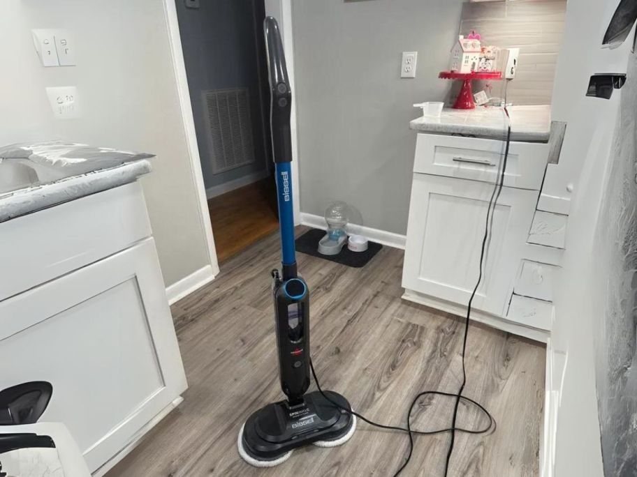 BISSELL SpinWave SmartSteam Scrubbing Steam Mop with Rotating Mop Pads upright in laundry room
