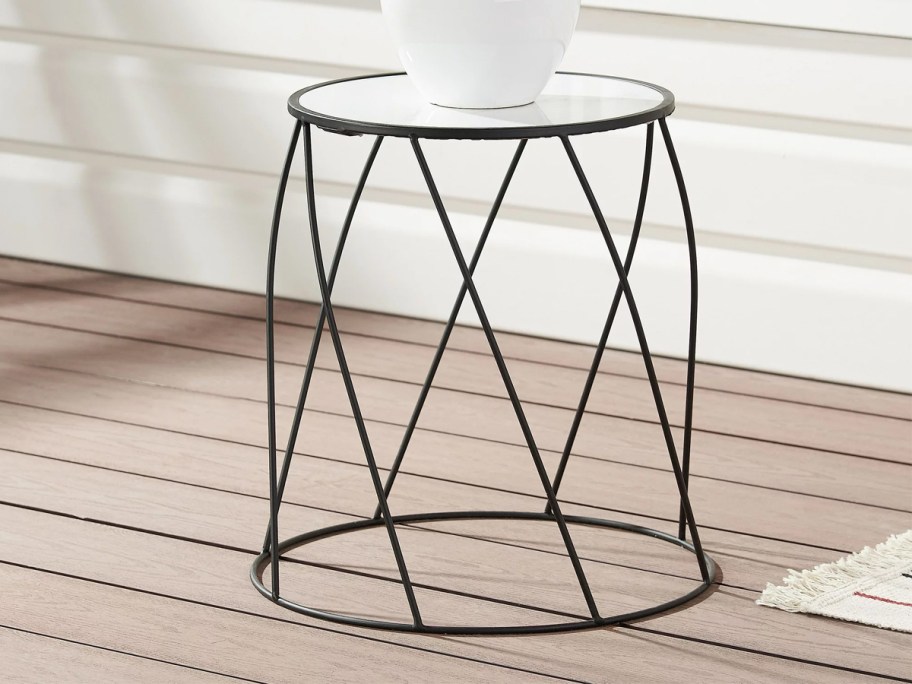 white pot on top of a marble top plant stand on deck
