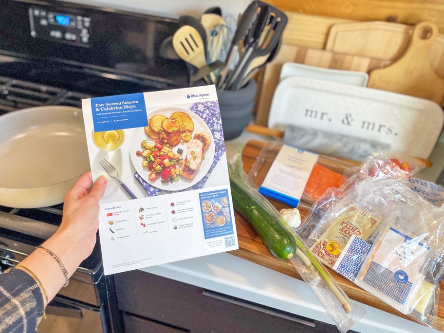 hand holding Blue Apron recipe card in front of ingredients