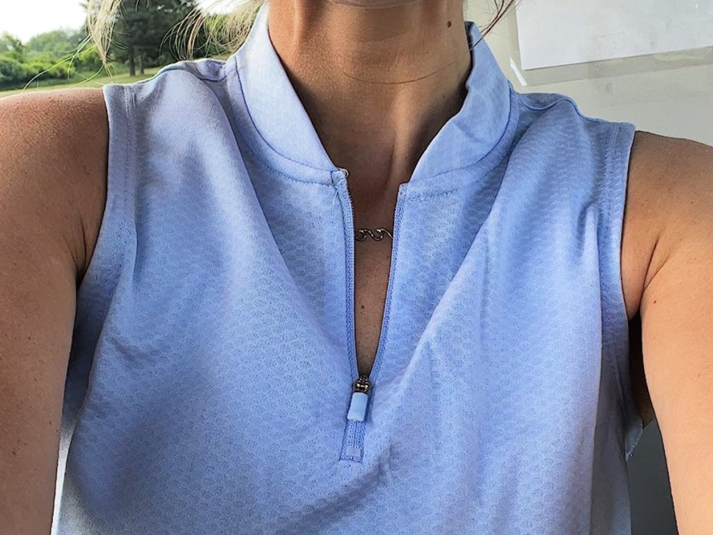 woman wearing light blue sleeveless golf polo outside