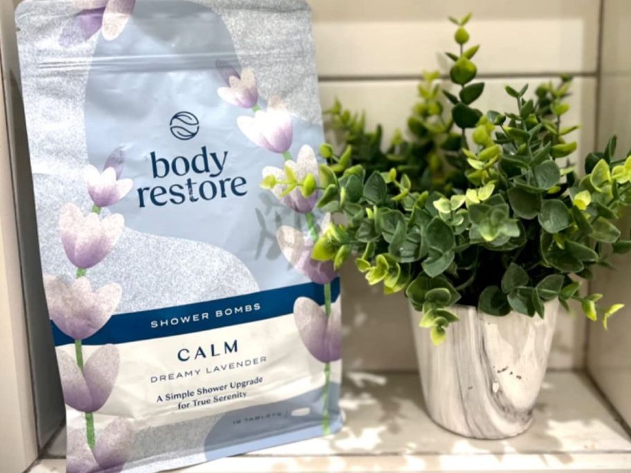 A package of Body Restore shower steamers next to a faux plant