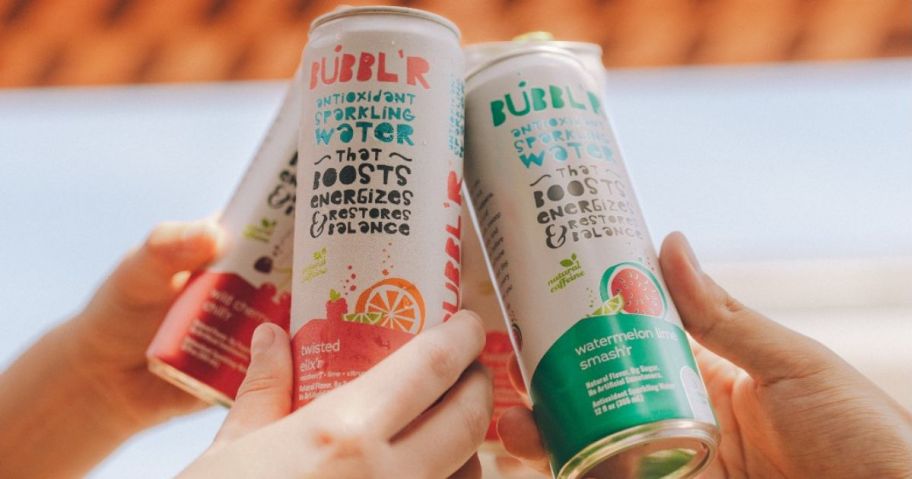 Hands toasting cans of Bubbl'r drinks