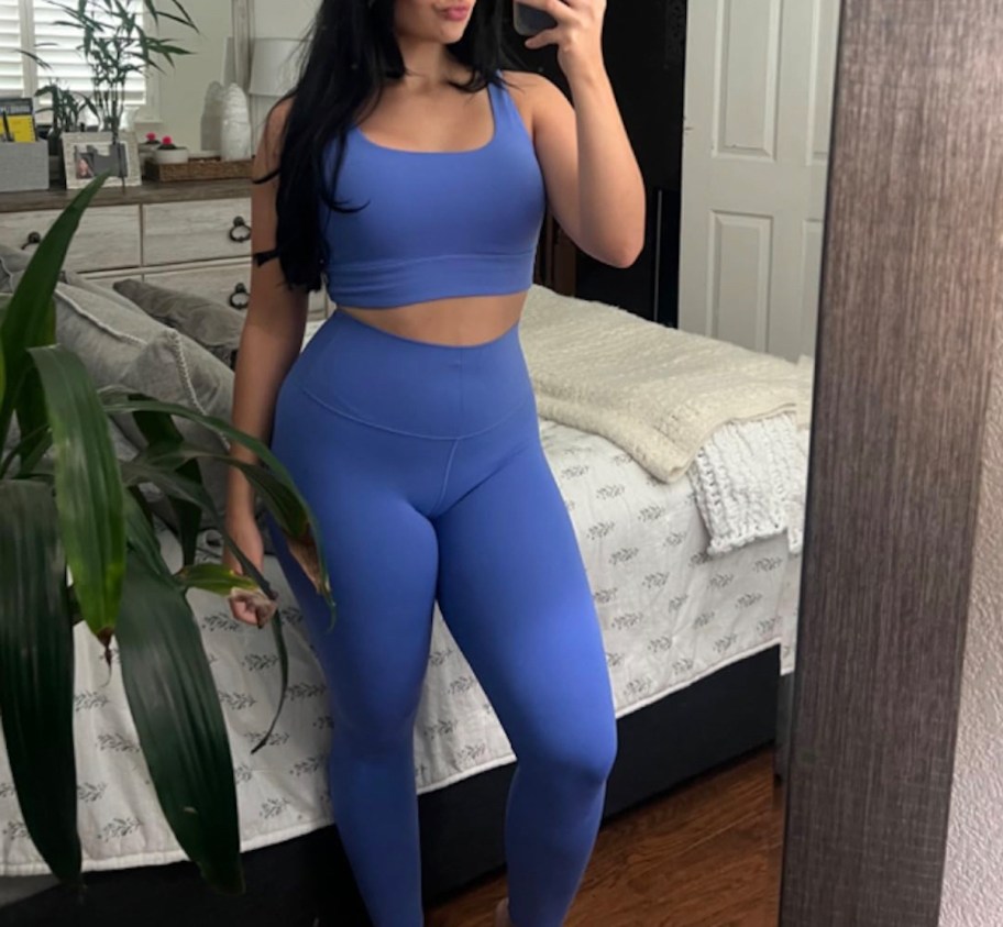 woman taking selfie in mirror wearing indigo blue workout outfit