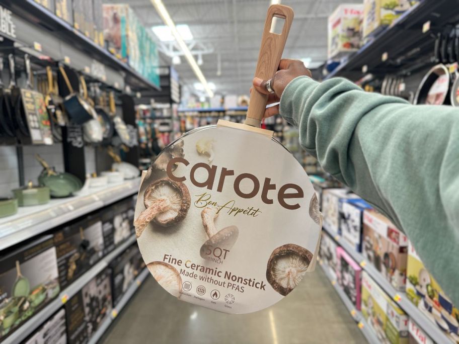 A person holding a Carote Bon Appétit Collection 5 QT Ceramic Sauté Pan in taupe