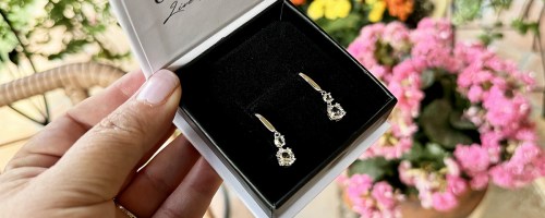 hand holding a boxed set of crystal earrings