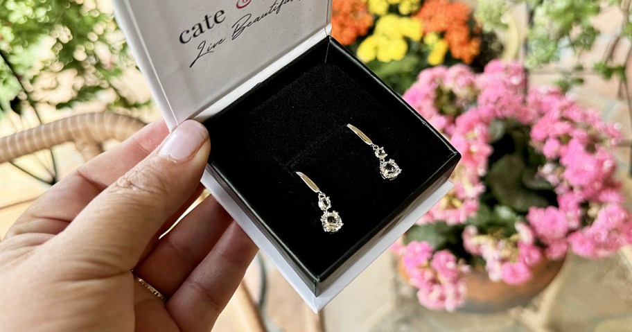 hand holding a boxed set of crystal earrings