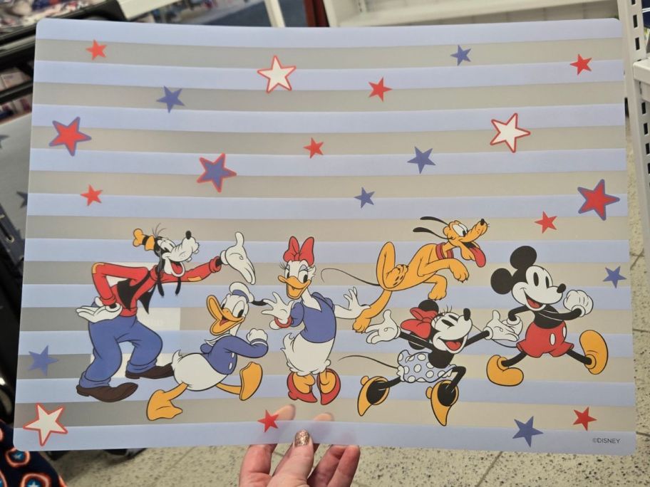 Hand holding up a Celebrate Together Disney Placemat