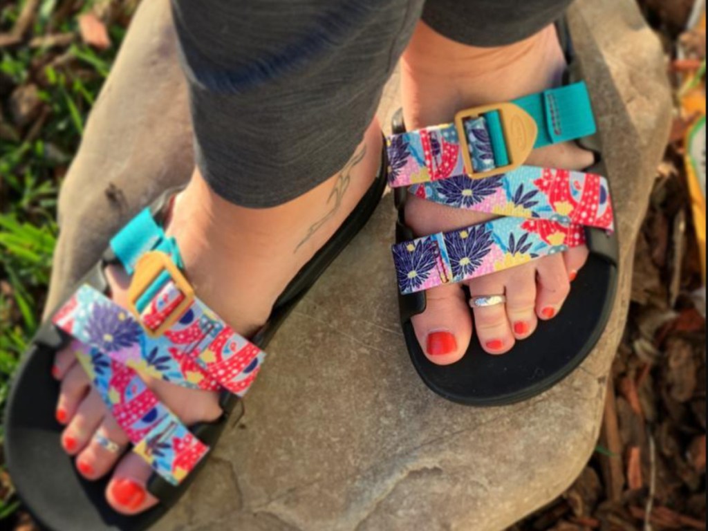 woman with red toenails wearing chacos slides