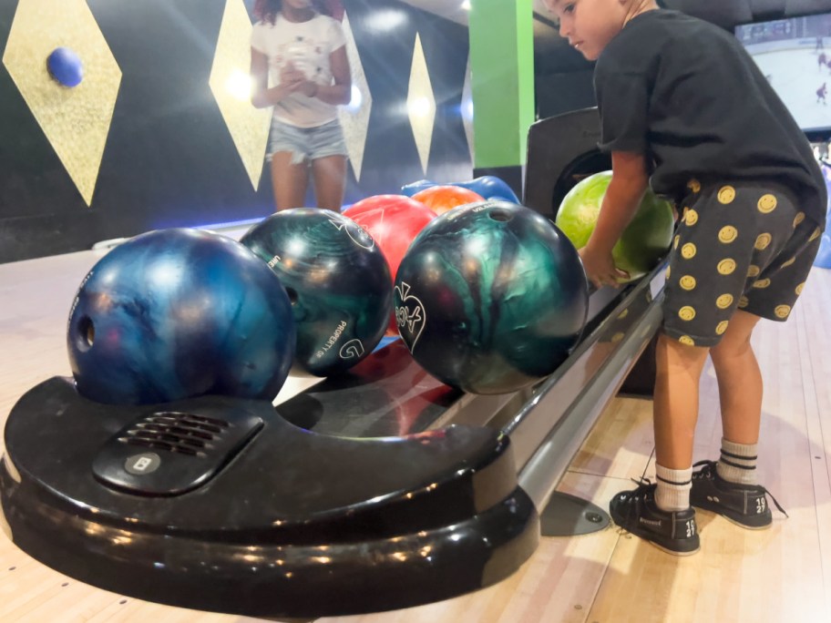 Child picking their preferred bowling ball from the selection