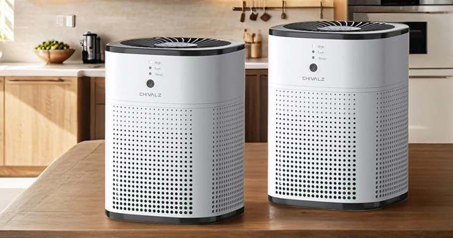 two white air purifiers on wood table in kitchen
