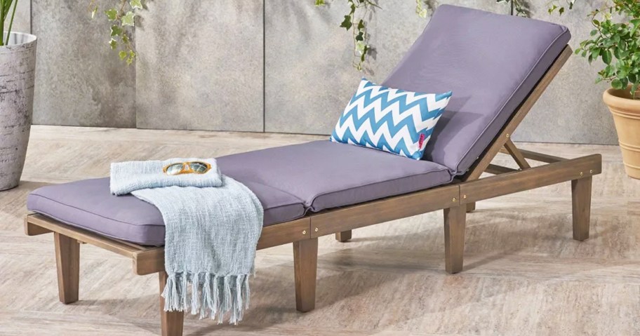 wood chaise lounge chair with blue grey cushions and throw blanket