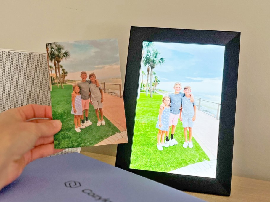 holding a photo near to the same photo displayed on a digital picture frame