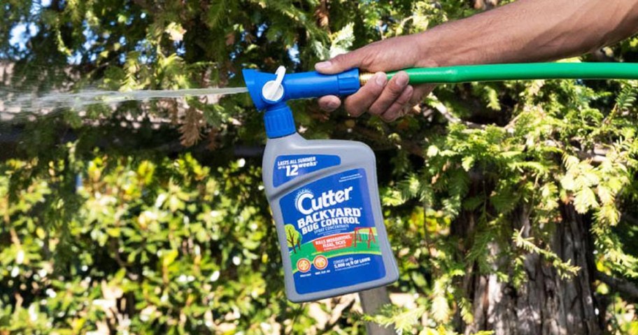 hand spraying Cutter Backyard Bug Control Spray in yard