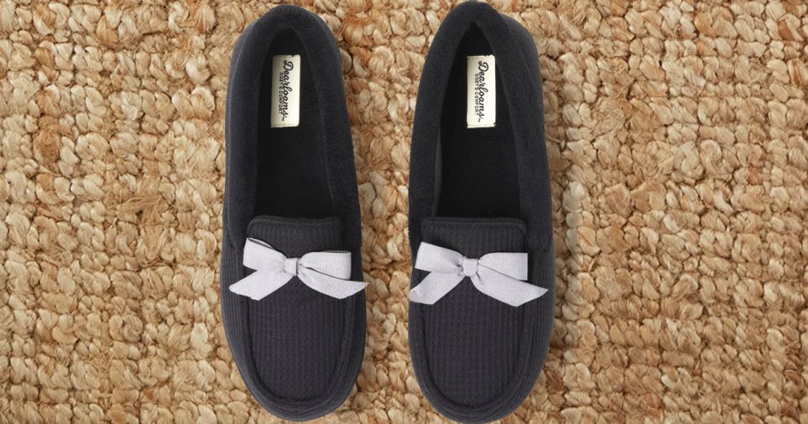 black slippers with grey bow on rug