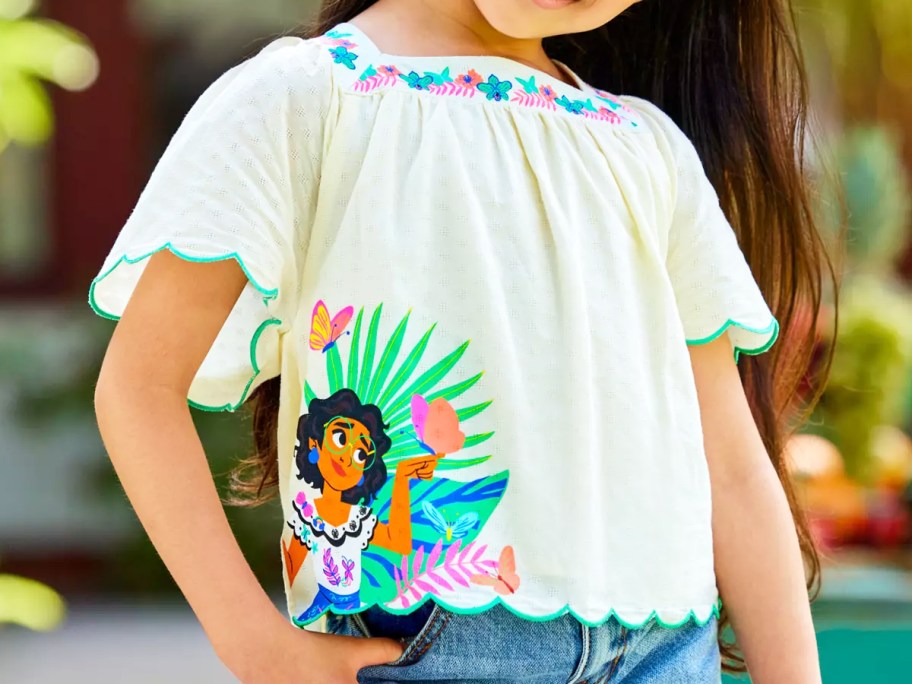 girl wearing a white disney encanto top