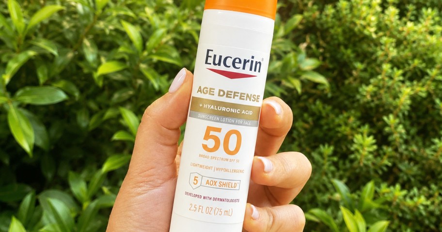 hand holding a tube of Eucerin Age Defense sunscreen