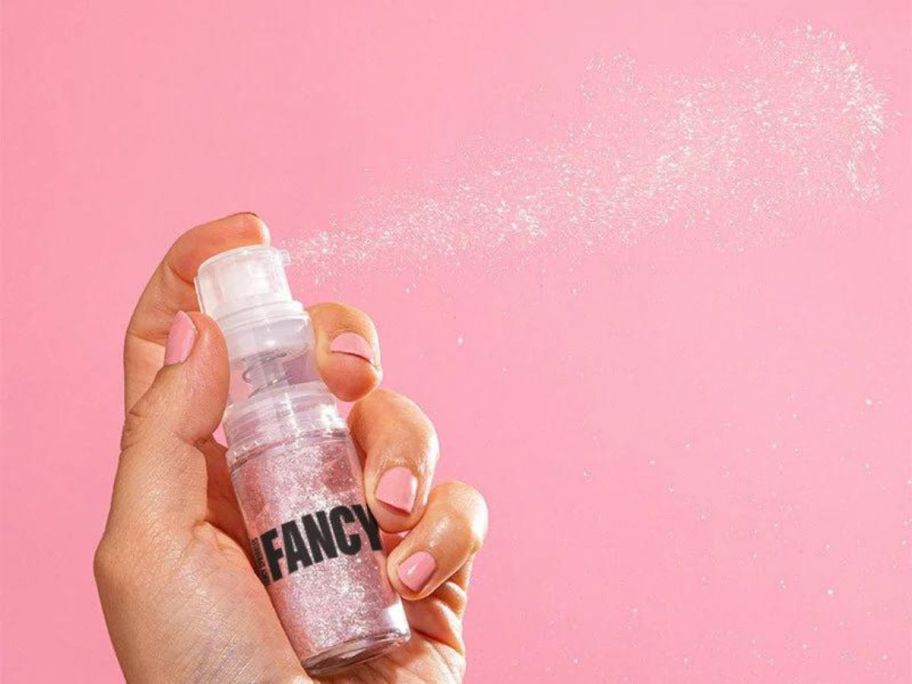 A hand spraying a Fancy Sprinkles Premium Edible Glitter Fancy Dusting Pump
