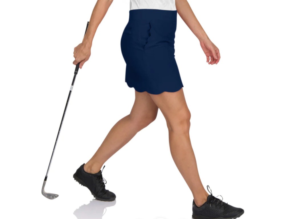woman in navy scallop skort holding golf club