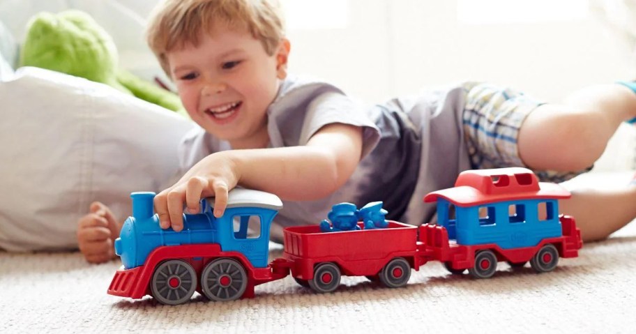 boy playing with blue and red train toy