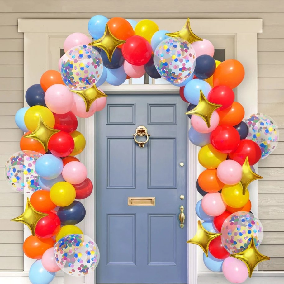 blue house's front door with a colorful balloon garland arch around it