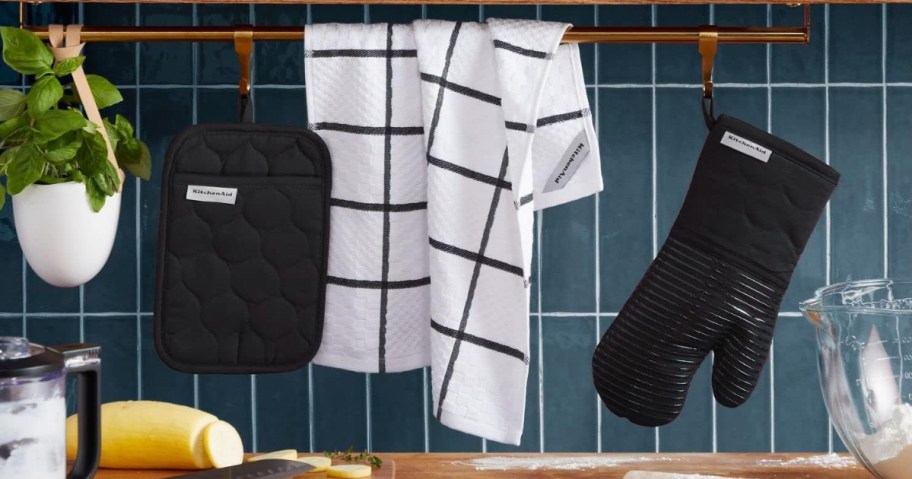 black and white kitchen towels and black oven mitt and pot holder in a kitchen