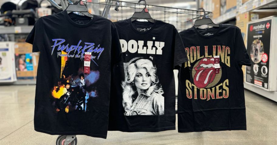 Prince Purple Rain, Dolly Parton and Rolling Stones graphic tees hanging on a Walmart cart in store