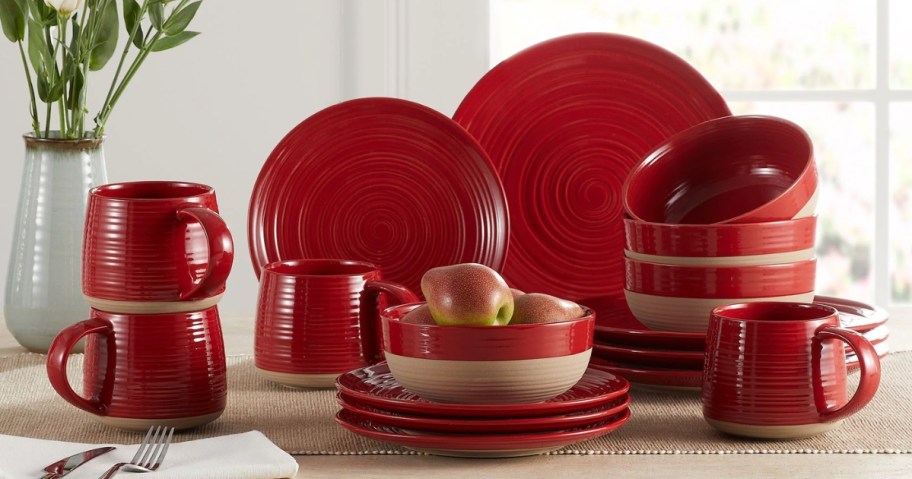 red and tan stoneware and clay dinnerware set displayed on a kitchen table