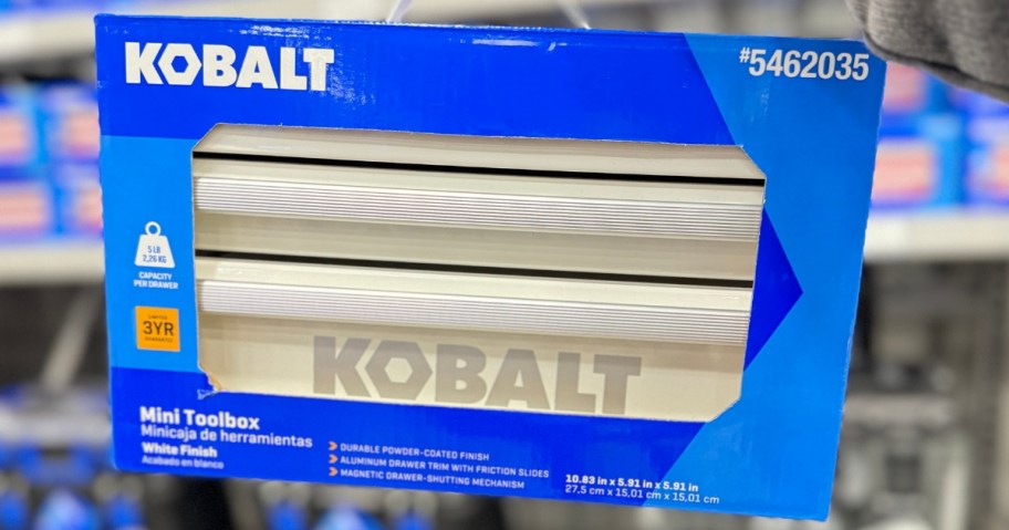 hand holding a blue box with a white Kobalt mini toolbox in it in a Lowes store aisle