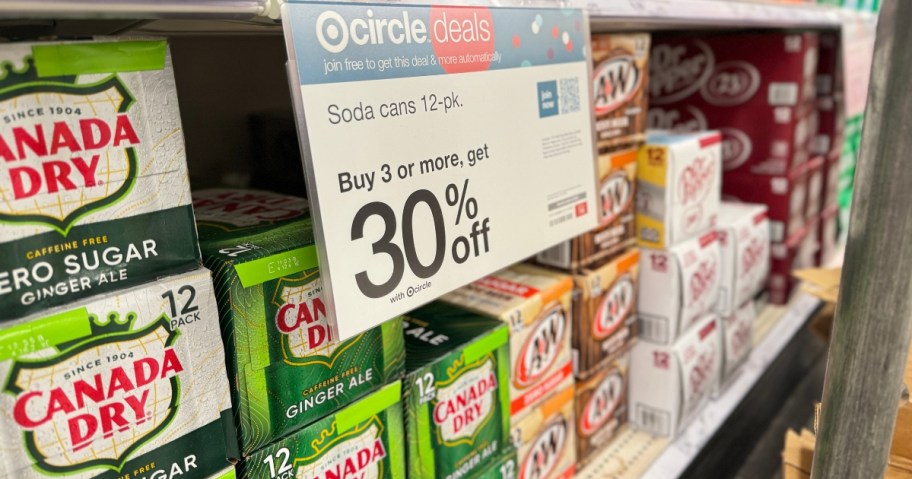 Canada Dry, A&W, Dr. Pepper and more 12 pack cans on shelf at Target with sign that says 30% off when you buy 3 packs