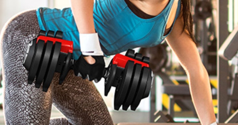 woman working out with a black and red adjustable dumbell