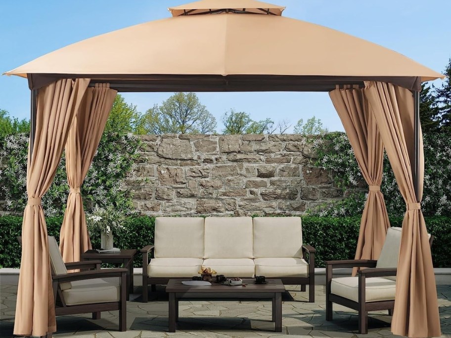 outdoor gazebo with khaki canopy and curtains on a back deck