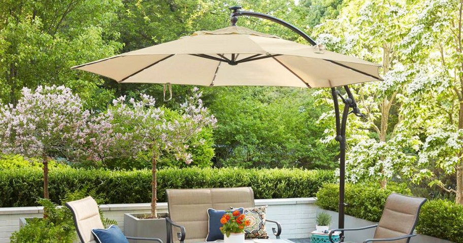 beige patio umbrella hanging over patio furniture set