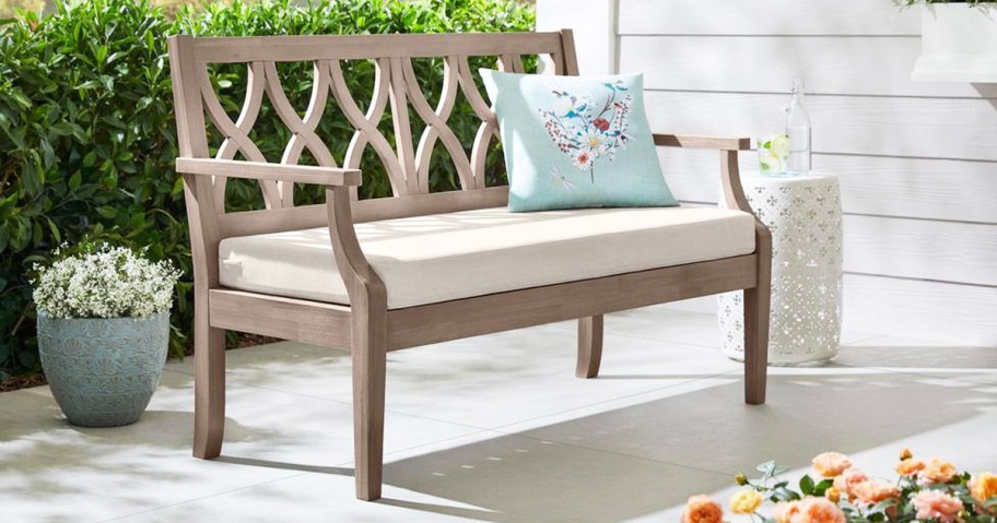 wood bench with white cushion and blue throw pillow