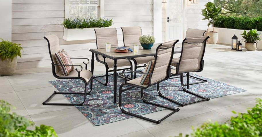 outdoor dining set with 6 chairs and table on a patio with area rug