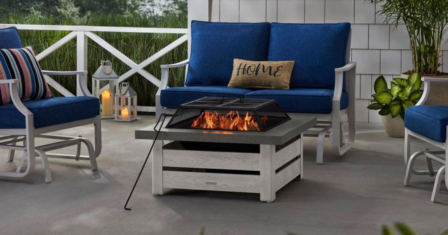 fire burning in white and grey fire pit near patio set