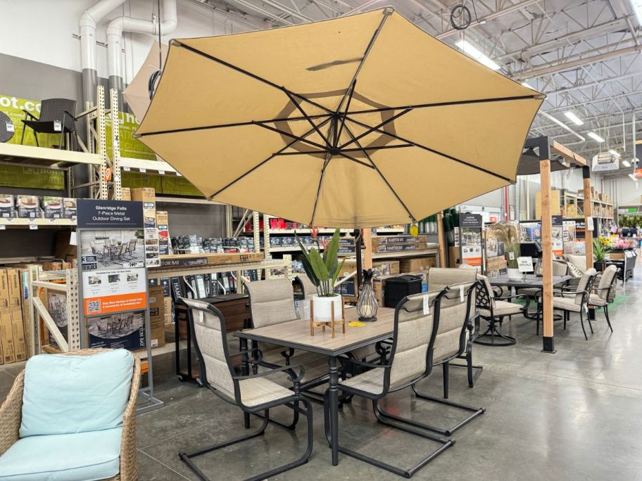 Hampton Bay Glenridge 7-piece outdoor furniture set and matching umbrella on display at Home Depot