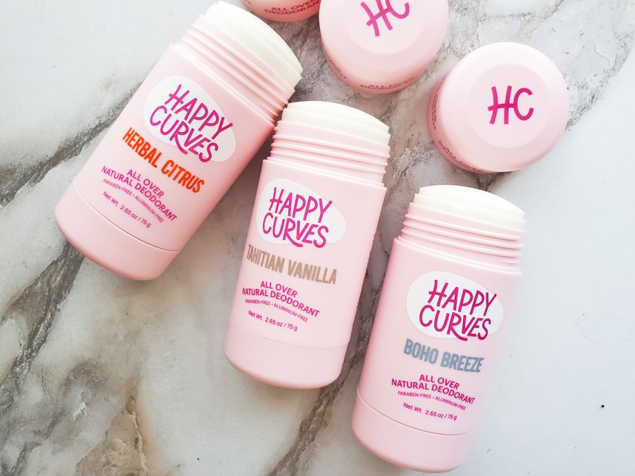 three pink tubes of Happy Curves Whole Body Deodorant with their lid off