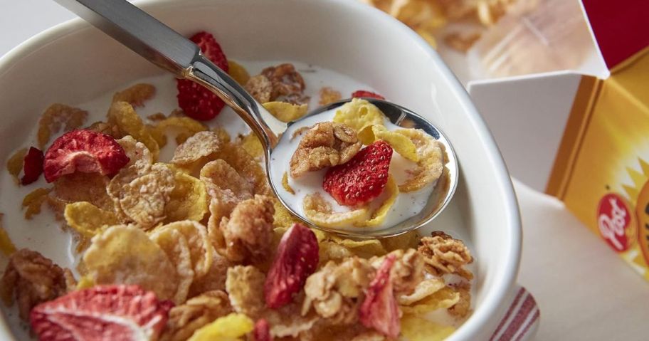 A spoon full of cereal from a bowl of Honey Bunches of Oats with Strawberries
