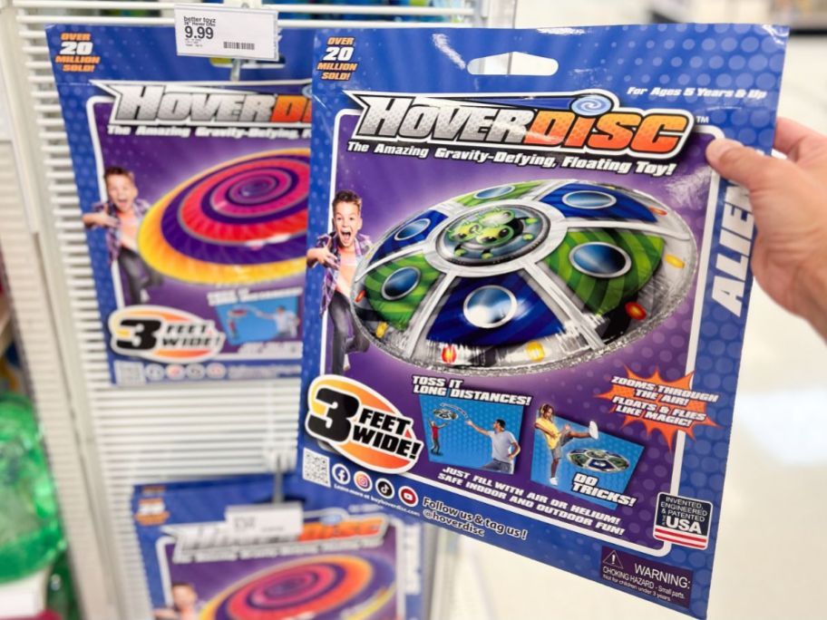 Hand holding a HoverDisc package next to the display at Target