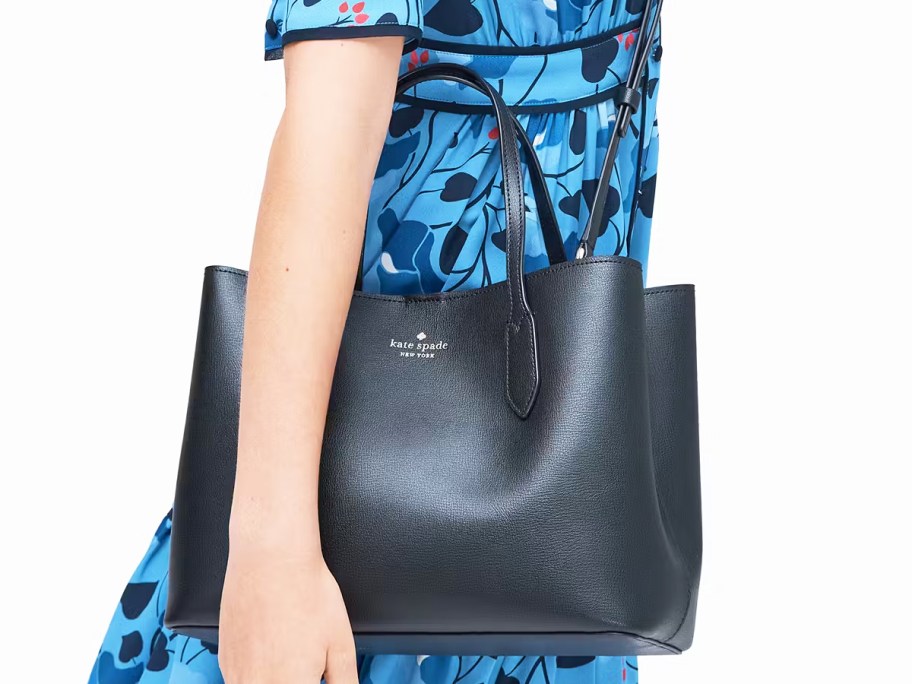 woman in a blue dress with a black kate spade purse