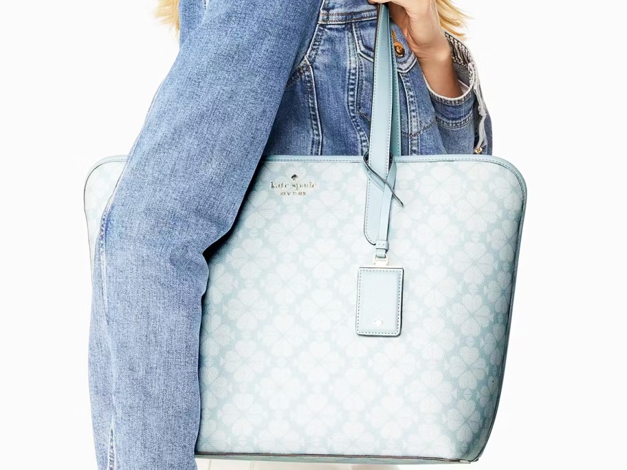 woman in denim jacket with light blue tote bag